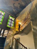 Standing in front of the Murals of Chapultepec Castle, with Alegoría de la Revolución Mexicana on the background and Mural de los Niños Héroes on the ceiling